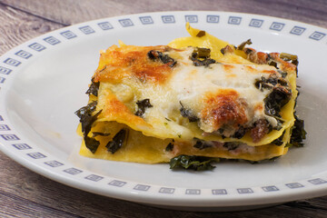 Lasagna with black cabbage, mozzarella and sausage.