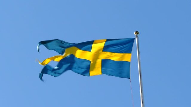 Close up of Swedish Flag waving on windy and sunny day. Static, low angle