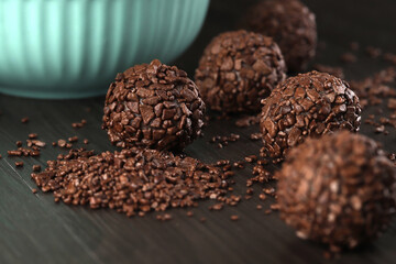 Brigadeiro - traditional Brazilian delicacy made from condensed milk, cocoa powder, butter and chocolate sprinkles. Granulated chocolate candy in selective focus