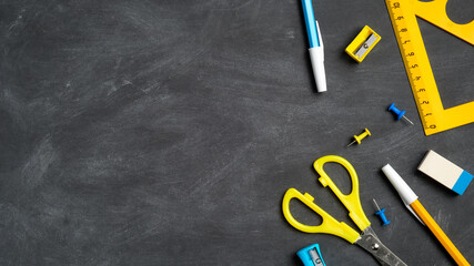Back to school concept. Flat lay school stationery on a black board background. Top view, overhead. © photoguns