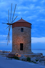 Fototapeta na wymiar Windmills, Rhodes island. View of the historic wind mills in the Mandraki Harbor area, at dusk. Greece