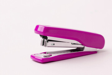 Pink stapler on a white background.