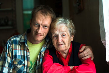 Portrait of a man embracing his grandmother.