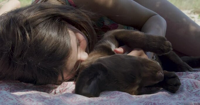 little girl sleepig with her puppy at the river in the pont du diable south of france occitanie