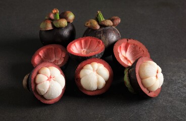 Ripped mangosteen fruit on black background.