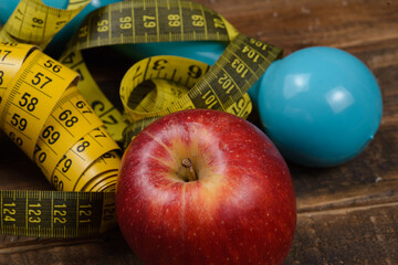 Weight control concept, with measure objects, and exercise weight, with an apple.