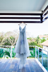 Wedding gown dress hanging on before outdoor wedding of tropical caribbean destination marriage matrimonial ceremony on the white sandy beach in Dominican republic 