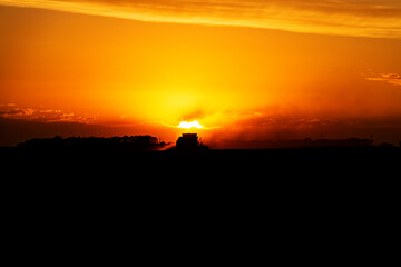 Fototapeta na wymiar Combine at Sunset