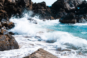 Olas rompiendo en las rocas en la orilla de la playa