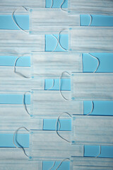 Disposable face masks on light blue background, flat lay. Protective measures during coronavirus...