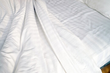 Fototapeta na wymiar Unmade and clean white bed with pillows and blanket