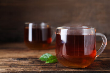 Tasty black tea on wooden table. Space for text