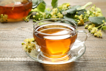 Cup of tea and linden blossom on wooden table