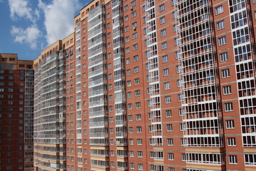 Fototapeta na wymiar modern multi-storey brick residential building with Windows on the facade