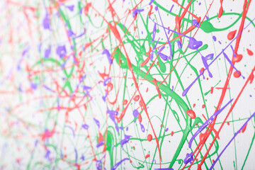 Colorful paint splashes on white canvas as background. Art and creativity