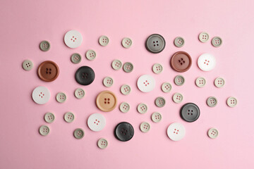 Many sewing buttons on pink background, flat lay