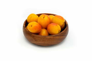 apricots on a wooden plate on white background