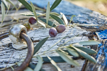 ripe violet olives with leaves on the wooden background