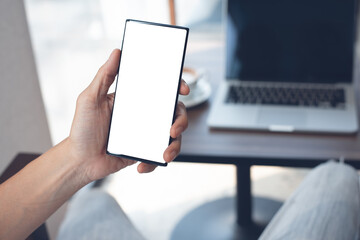 Mockup of man using blank screen mobile phone working in coffee shop