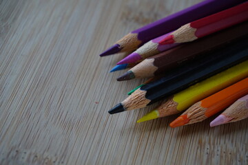 Obraz premium Arrangement of colored pencils on wooden background. copy space for text. back to school concept. rustic vintage concept