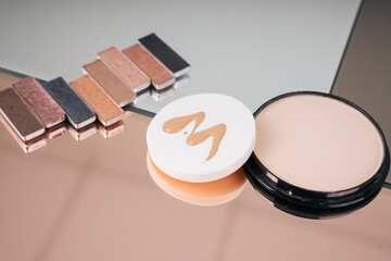 Cosmetics palette tones template, powder puff jar on mirror table.