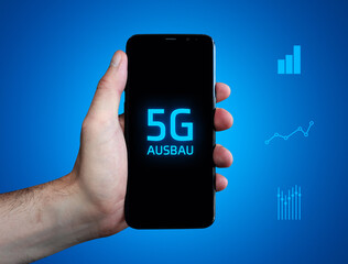 5G-Ausbau. Hand hält Telefon (Handy). Wort auf Display. Diagramme auf Hintergrund blau. Business
