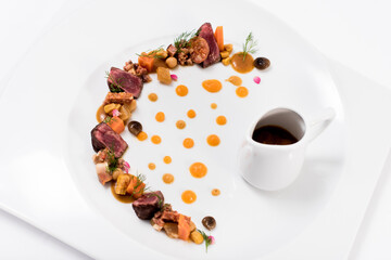 A plate of meat, vegetables and sauce