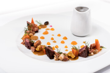 A plate of meat, vegetables and sauce