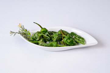 A plate of green peppers on a white background