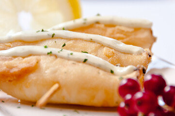 A plate of breaded fish on a white background
