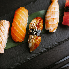 Nigiri sushi set on a black slate tray. The view from the top. Traditional Japanese food.