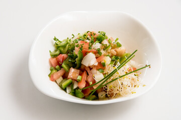 A plate of tomato and cheese salad on a white background