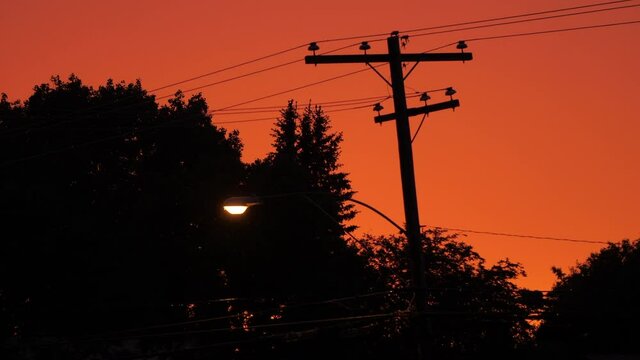 Street Light and Power Lines with a Orange Sky in the Background