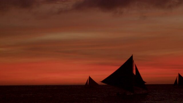 Static Silhouette Shot Of Sail Boats Sailing During Sunset In Boracay