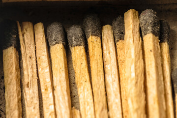 Match sticks are laying inside a match box in parallel