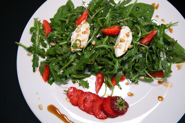 Salad with arugula, cream cheese and strawberries. Salad with arugula and strawberries. Rucola and strawberries.