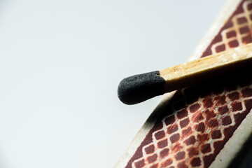 Isolated match stick kept over the edge of a matchbox in a white background. Space for text in left
