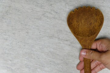 hand holding a wooden ladle