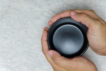 hand holding a black ceramic soup bowl
