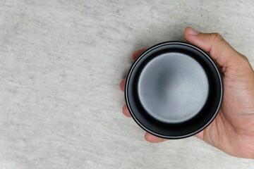 hand holding a black ceramic soup bowl