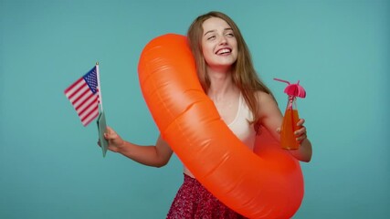Carefree cheerful girl in dress dancing inside big rubber ring with passport and US flag, drinking fresh juice, relaxing on tourist tour in America, summer vacation, beach party. studio shot isolated - Powered by Adobe