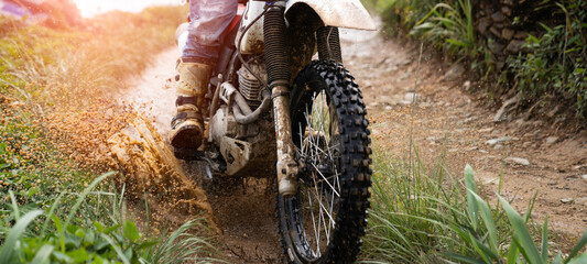 rider on a motorcycle rides a puddle of mud  splashing around