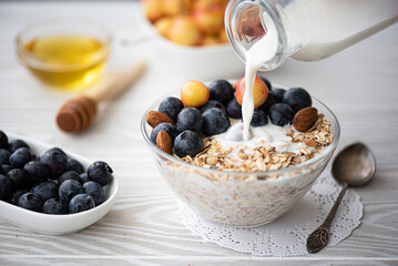 breakfast with blueberry and yellow cherries oatmeal poured milk