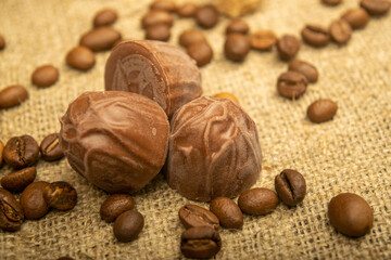 Coffee beans and chocolate on a homespun fabric with a rough texture. Close up.