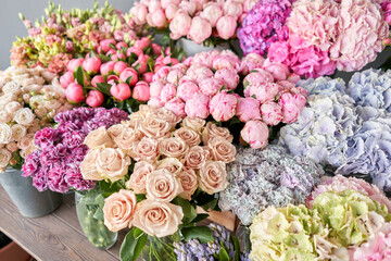 Many different colors on the stand or wooden table in the flower shop. Showcase. Background of mix of flowers. Beautiful flowers for catalog or online store. Floral shop and delivery concept. Top view