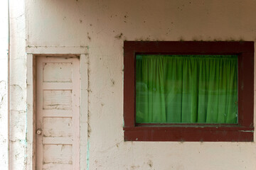 Window with green curtains and a door