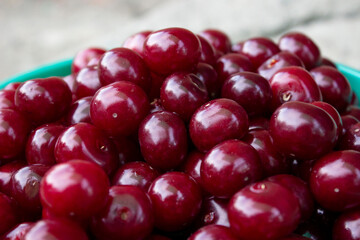 Red cherry, large. A full Cup of ripe berries. Merry.Gray background.