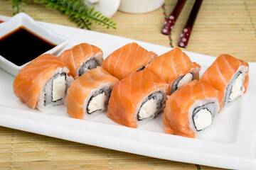 Sushi on a white plate with sauce and seasonings