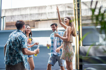 multiethnic People dancing and having a good time at an evening party by the pool