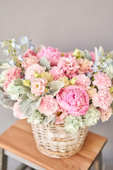 Beautiful flower composition a bouquet in a wicker basket. Floristry concept. Spring colors
